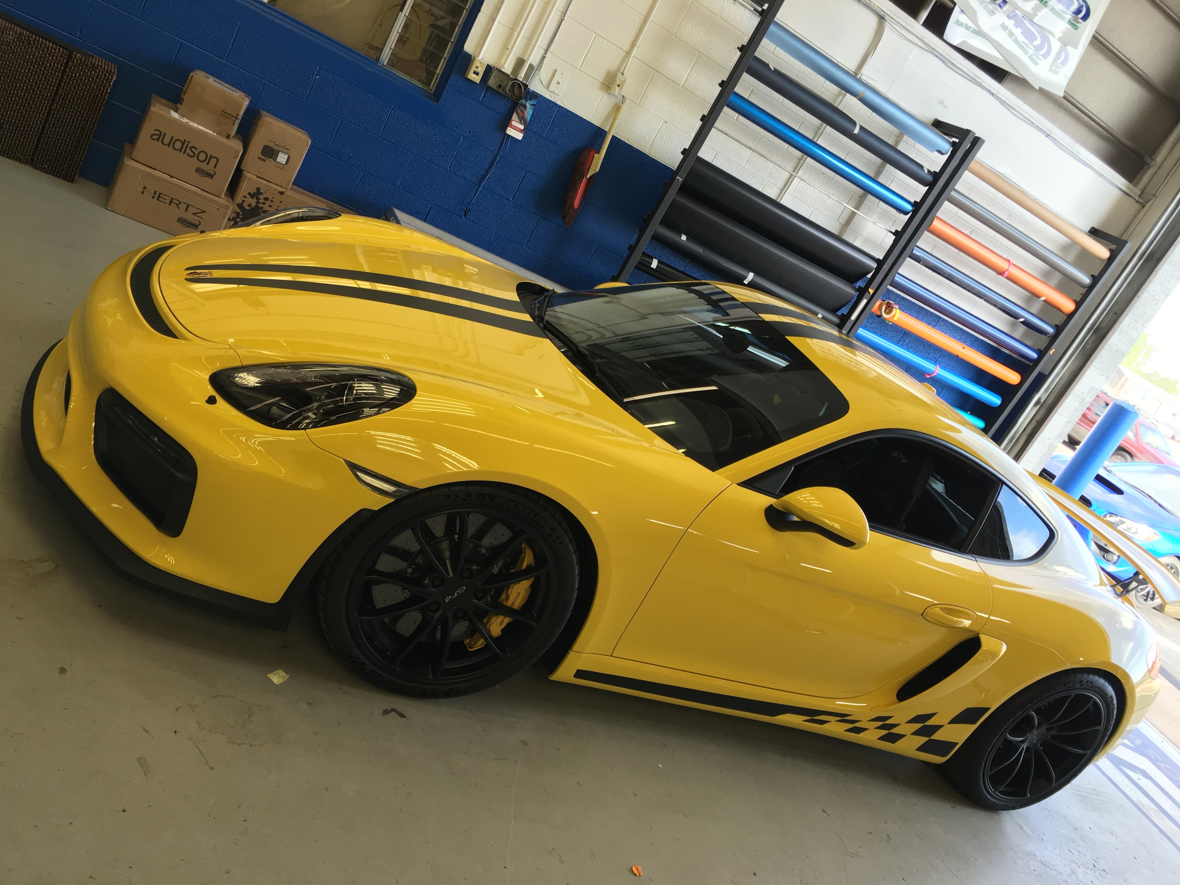 Yellow Porsche GT4 overhead view in shop